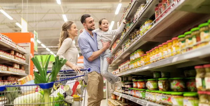 Retail and Grocery Family grocery shopping with a cart full of produce and other food items