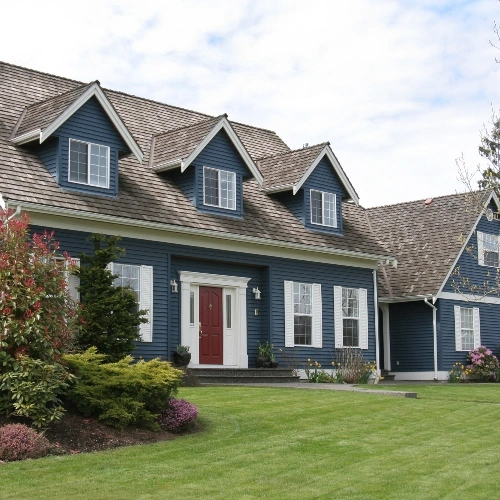 Scenic view of a residential home with a beautifully landscaped lawn